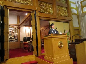 Rev. Mariko Nishiyama speaking, from inside the main shrine room at the temple