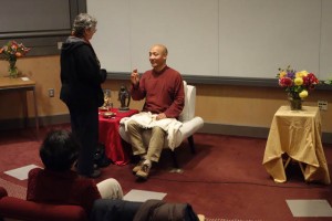 Anam Thubten (seated) discusses the dharma with Susan Dixon (standing)