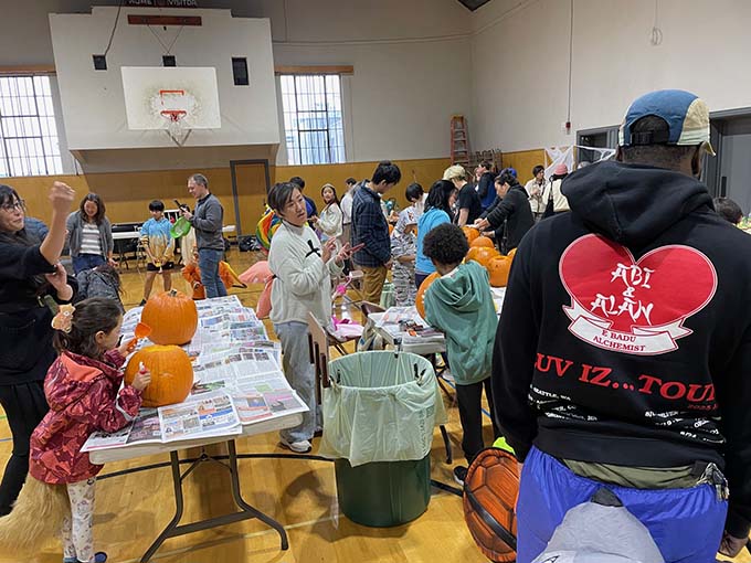 Children and adults participate in the Halloween party in the gym.