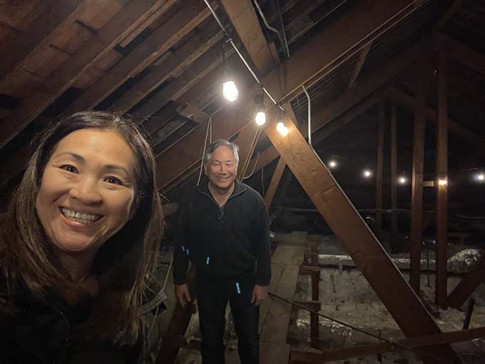 Volunteer reconstruction project managers Grace Tazuma and Gary Shibata, inspect the attic of the main hall.