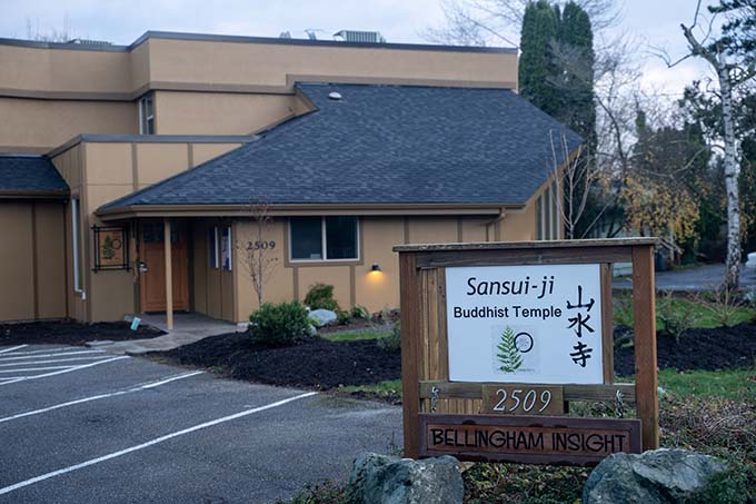 View from the road of Red Cedar Zen’s Sansui-ji Temple sign, with the Bellingham Insight sign hanging below, and the temple itself in the background.