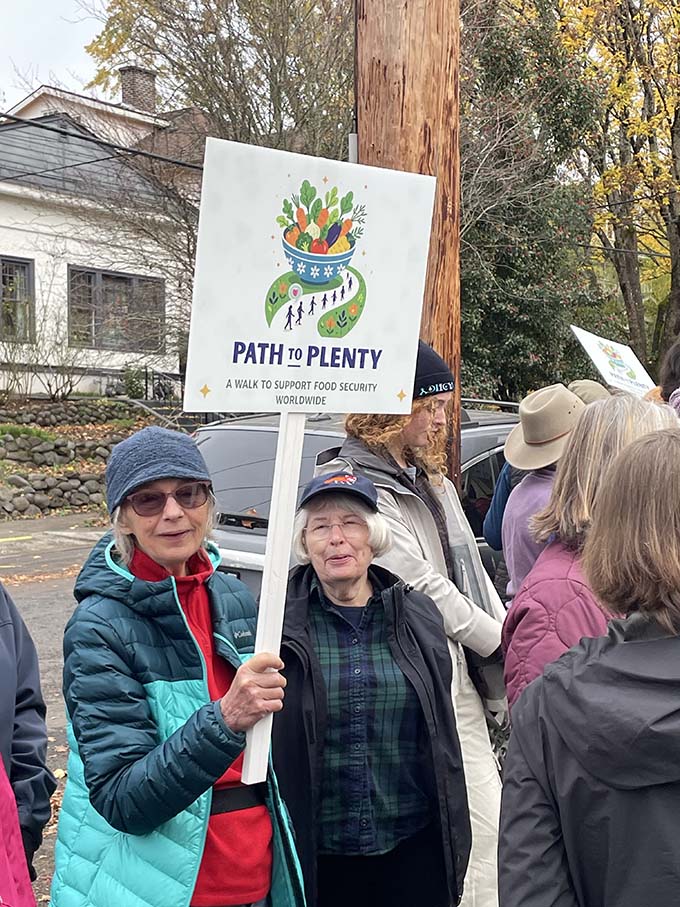Walk participants Suzan Wilson (left) and Genie Barnes (right) with a path to plenty walk sign.