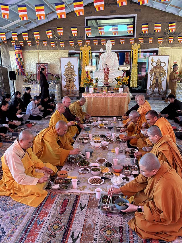 Monks and others are offered a traditional meal in the pavilion next to the temple