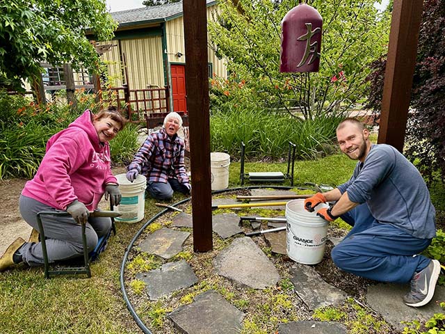 Weeding the stones under the temple bell