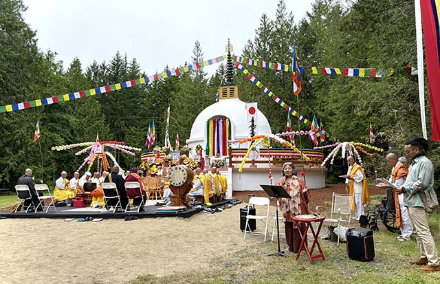 The curtains of the Buddhist-style shrine (niche) await the opening. Buddhist flags from Sri Lanka, Korea, Tibet, and various regions of Japan adorn the ceremony