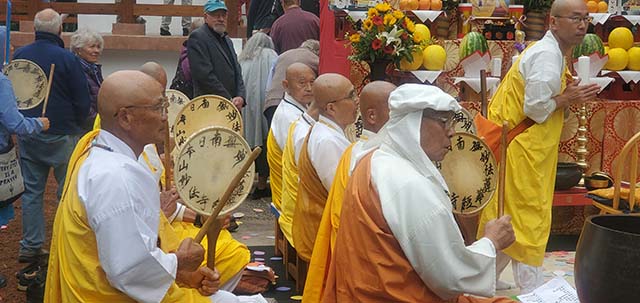 Monks celebrating the opening of the stupa by beating on traditional uchiwa-daiko drums, representing a call for peace