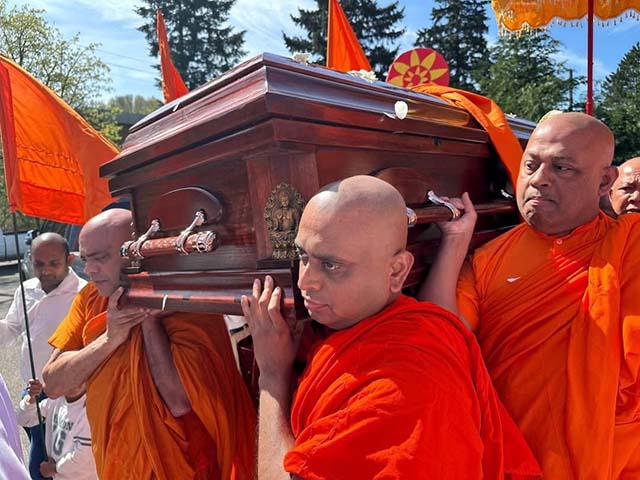 Senior Theravāda monks lead by Devananda Thero, and the current abbot Punnasiri Thero, bear the casket of Venerable Pagnananda during the final procession in honor of a revered teacher