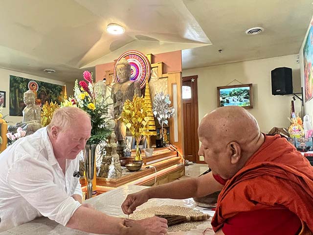 Ven. Pagnananda gives blessings with a sacred thread to a lay supporter, a Buddhist practice offering guidance and protection