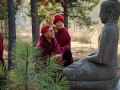 Khenpo Lodro Donyo Rinpoche with basalt Buddha statue near the cloisters. Lama Michael Conklin and Lama Tashi Dondrup behind