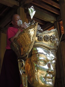 Lingtrul Rinpoche affixing the vajra atop Guru Rinpoche’ lotus hat