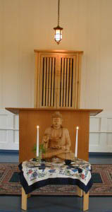Zen center members put the Buddha in place for each sit. Behind is the ark of the covenant, the place where the Jewish Torah is traditionally stored