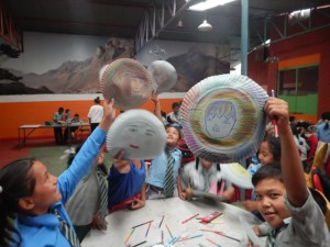 Students hold emotion masks at Healing Arts Nepal camp