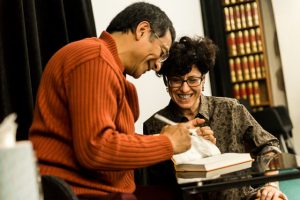 Karen de Luna, co-coordinator of the weekend teaching, laughs as Ponlop Rinpoche signs a book for her husband, Cadin Batrack