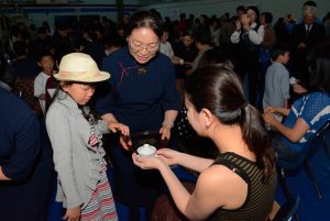 A child offers tea to her mother, during the tea offering ceremony