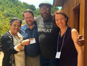 Happy new teachers Bonnie Duran, Tim Geil and Keri Pederson, at Spirit Rock. Embracing them is Andre Alton Hardy, a former Seahawks player who is now an author, grad school student, and partner of Against the Stream co-guiding teacher JoAnna Harper.