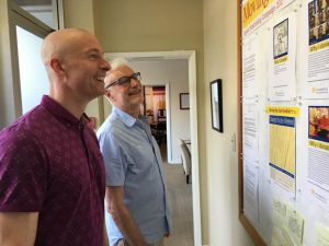 Zachariah Finley (foreground) and Rolf Erni check up on the fundraising thermometer in our current center.