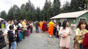 People line up for an alms-giving ceremony, a traditional part of Southeast Asian Buddhist culture