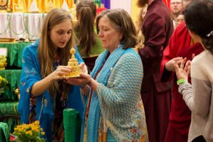 Ritual offerer (chödpön) Rita Pichlhoefer, of Vienna, Austria, assists Lisa Scott of Bend, Oregon with her offering