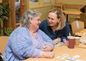 Recovery Café Co-Founder Killian Noe shares a moment with a Member during a card game.