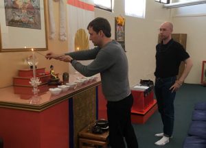 David Cook opens the shrine for the weekly get together of the Young Meditators group. Cory Paulo observes so he can open the following week