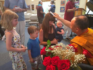 Khenpo blesses a young family after giving a talk in Ashland, Oregon