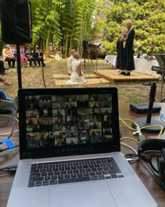 The Zoom broadcast of the outdoors wedding of Sara Shinei Monial and Danny Soten Lynch, with a small group of people outdoors