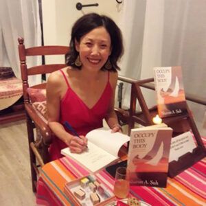 Suh signing her book, “Occupy This Body,” about her journey from an abusive childhood
