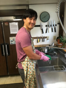 Vance Pryor pitches in to wash dishes, after a meal during the training