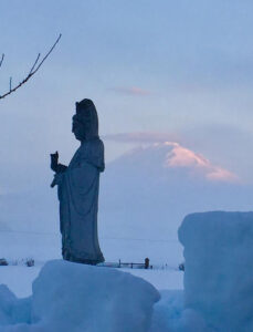 A statue of Avalokitesvara, representing compassion, with Mt. Adams in the background
