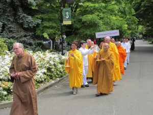Hirsch leading a 2013 Vesakha procession through the Seattle University campus, followed by monks from Chua Co Lam and Seattle Meditation Center
