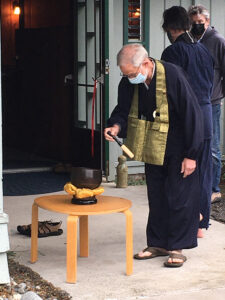 Sangha member Wes Borden strikes a keisu (gong used during chanting) 108 times, at the meditation HALL entrance, as part of the blessing ceremony