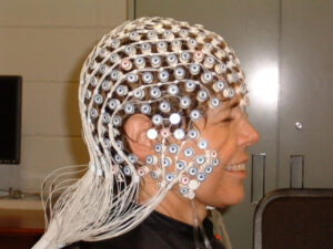 Her head wrapped in Electroencephalography (EEG) sensors, Woollacott is tested on the relative effects of meditation and exercise on attention focus