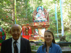 Tibetan lama and Longchen Nyingtik scholar, Nyichang Rinpoche, with Diane in front of Guru Rinpoche statue and koi pond at Williams, Oregon