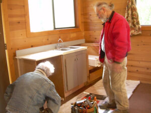 Friends Bruce Dobson and Brent Naylor installing a kitchen in the Oregon cabin