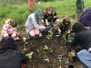 Cupid Amelia Hale and Max Mishaga help students planting seedlings