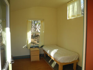 The simple retreat cabins include a bed, several windows, and a place for an altar and practice