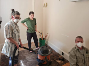 Sangha members removing old carpet to prepare for building expansion