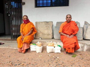 Two nuns in Nagpur, India, with essential donated requisites of food that support their survival and practice