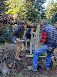 Derek, a current operations manager, working with a volunteer team to replace the old grape arbor with a lovely new design