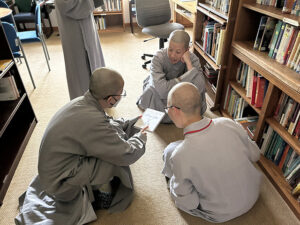 The Dharma Drum Mountain nuns examine a book in the abbey’s library, to expand their knowledge of Tibetan Buddhism