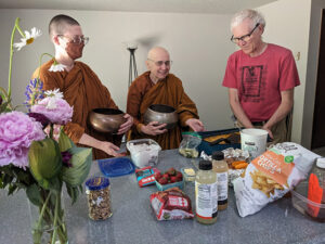 Matthew West offers meal dana to Ayyā Suvijjānā and Ayya Niyyānika, at the new Passaddhi Vihara in Olympia