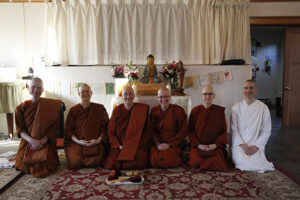 Gathered monastics include Ajahn Nisabho, Ayya Niyyanika, Ayya Anandabodhi, newly ordained Samaneri Junha, Ayya Ahimsa and Anagarika Sarah