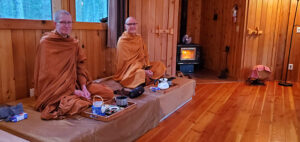 Wat Metta monks Ajaan Peter and Than Will, seated in the sala for the 6 p.m. offering of allowables