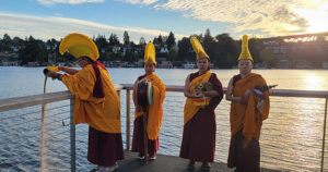 Geshema Yeshi Sangmo pours the blessed sand into Seattle’s Portage Bay, in hopse that the sand will spread with the natural flow of the water to benefit as many sentient beings as possible