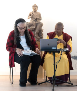 Local Dharma Leader Nana Gyesie (with microphone), speaking at a gathering of the Thursday Night Sangha in the main hall