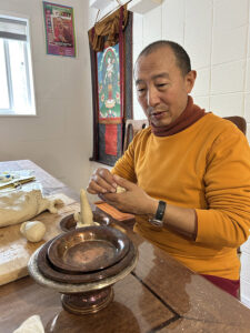 Ven. Lama Zopa making torma, ritual objects of Tibetan Buddhism, partly made of butter
