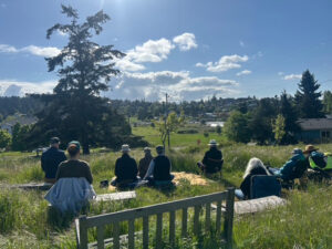 Morning meditators in May, 2025, on the land where Camas Hall will be  built